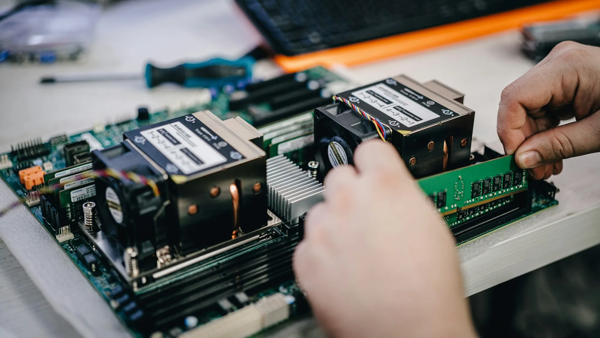 Hands fitting memory into a server motherboard